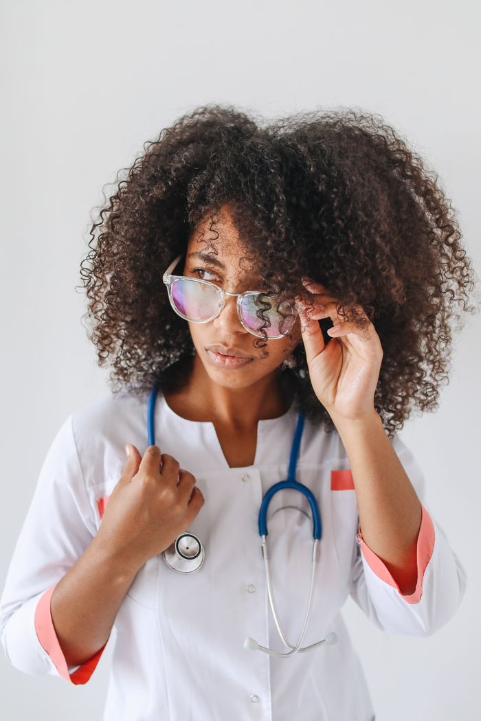 gallery-03 Close-up of a female doctor adjusting her glasses, exuding confidence and professionalism.