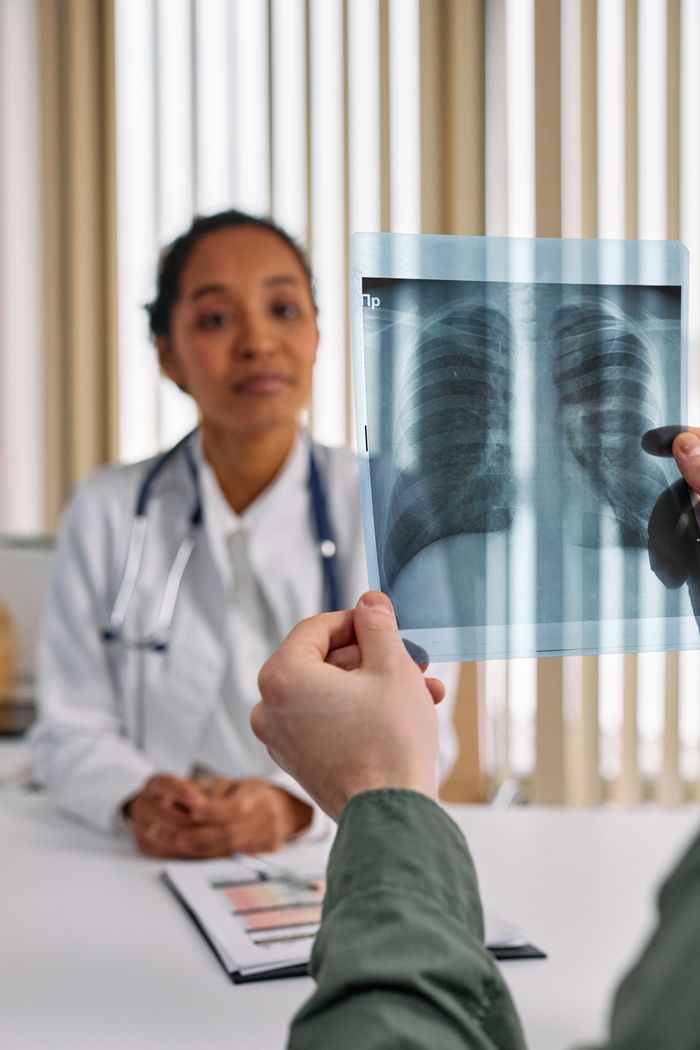 A doctor reviews a patient's chest X-ray results during a medical consultation.
